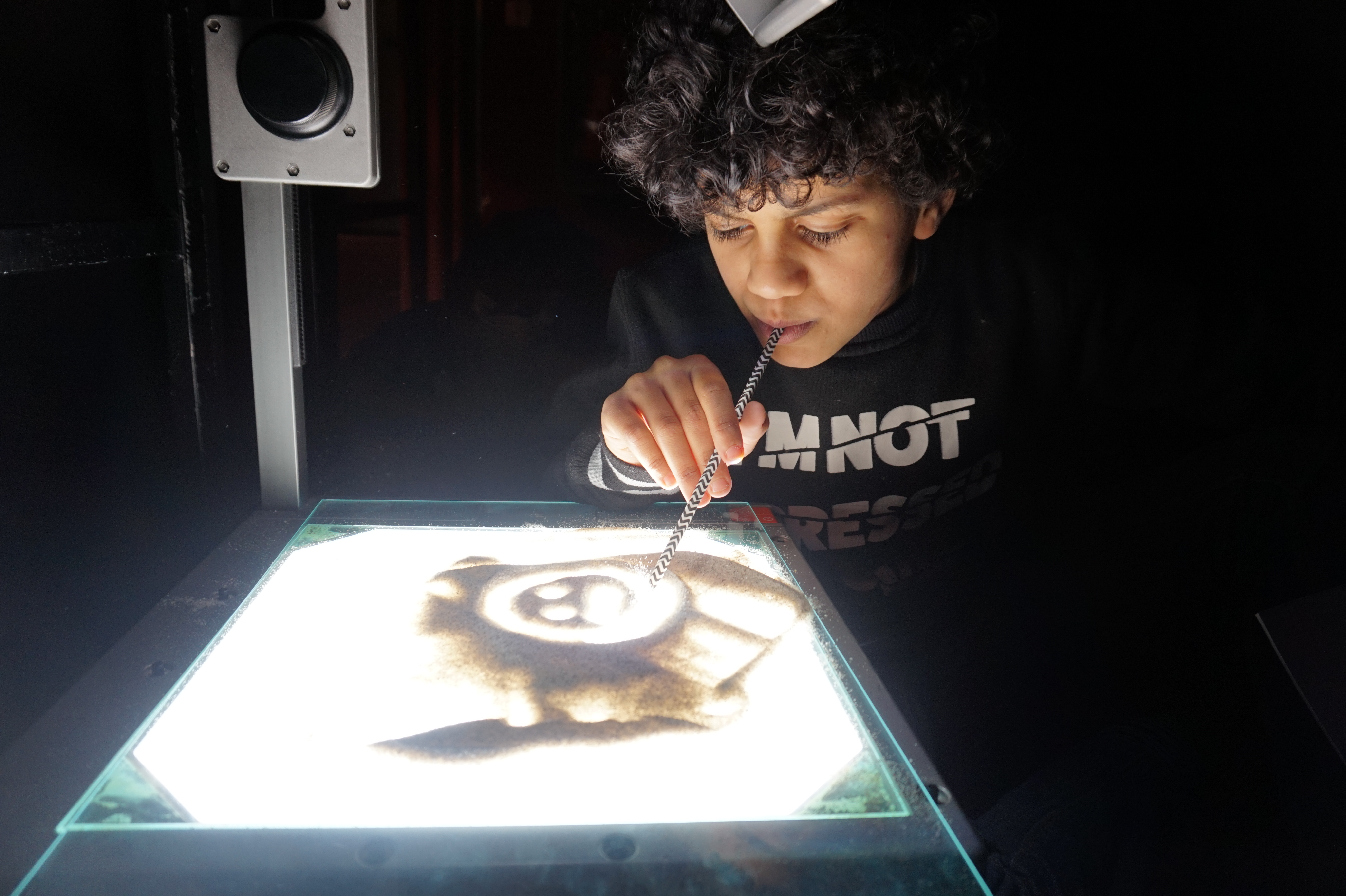 Ein Kind malt ein Bild auf einem Overhead-Projektor