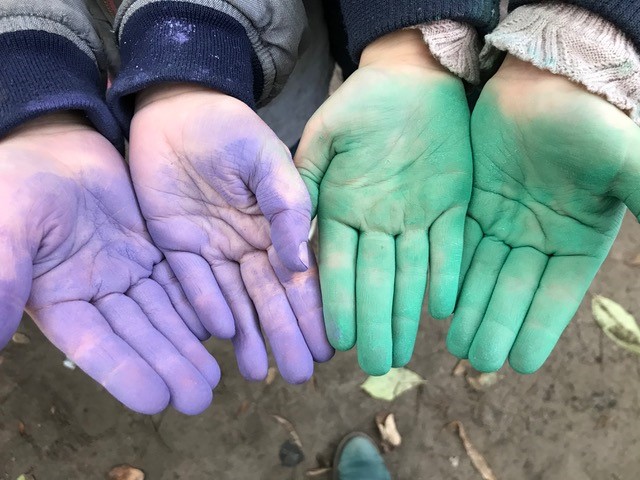 gefärbe Hände in grün und voilett nach einer Klopfaktion