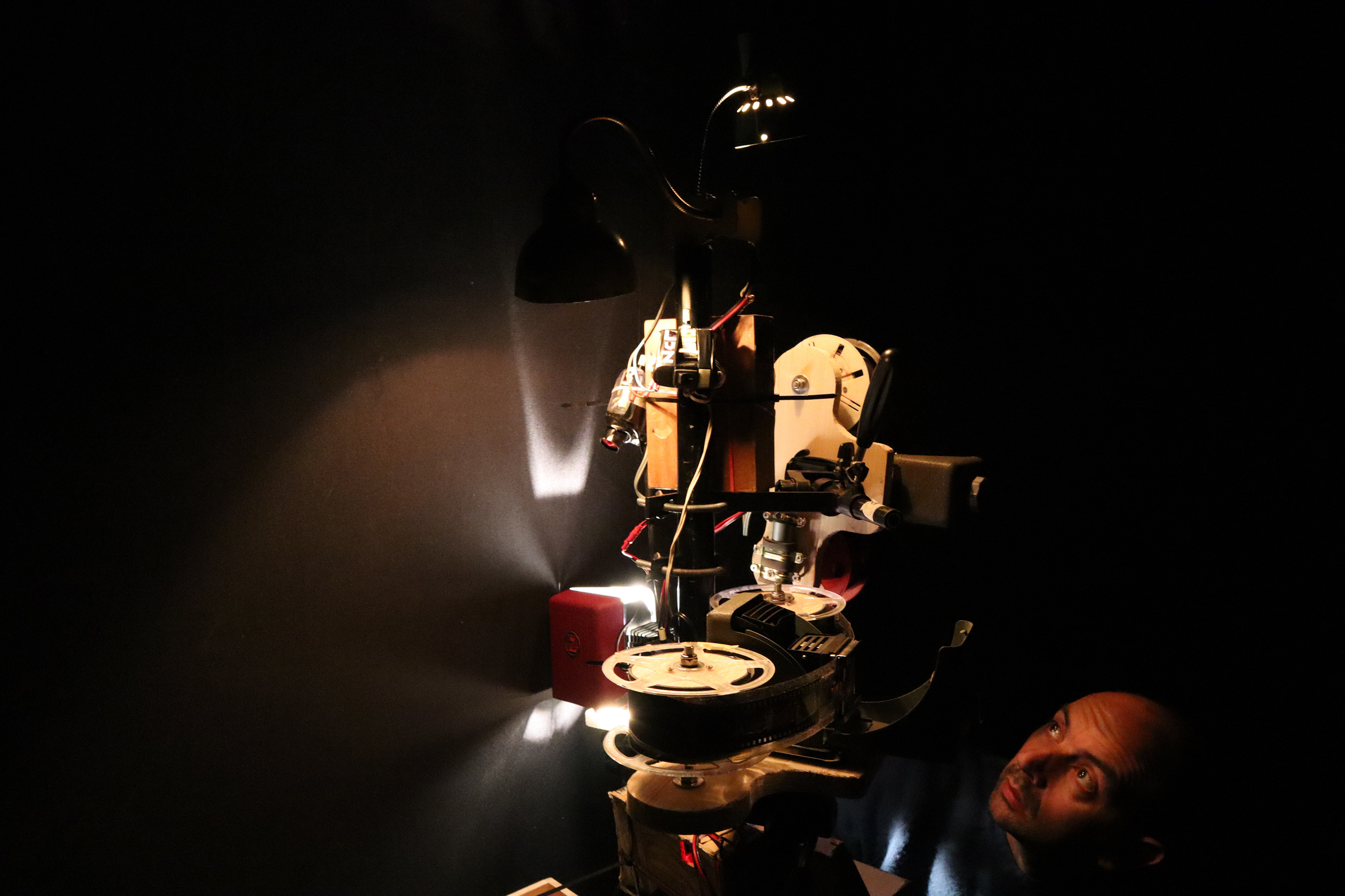 Ein multifunktionaler Apparat aus Spulen, Licht und kleinen Motoren wird von einem Mann betrachtet.