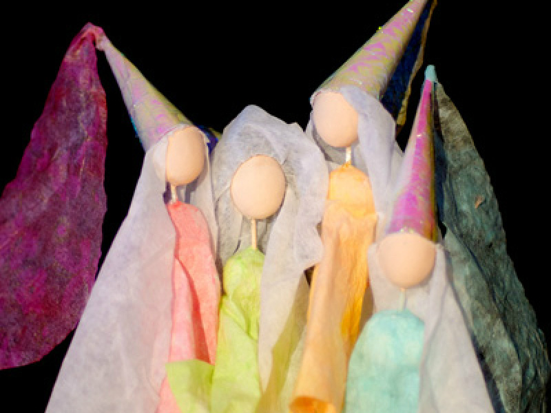 Die drei Feen aus Dörnröschen, dargestellt als bunt gekleideter Figuren mit runten, gesichtslosen Holzkopfkugeln. Sie tragen lange Kleider und spitze, lange Hüte mit herabhängenden Stoffteilen.