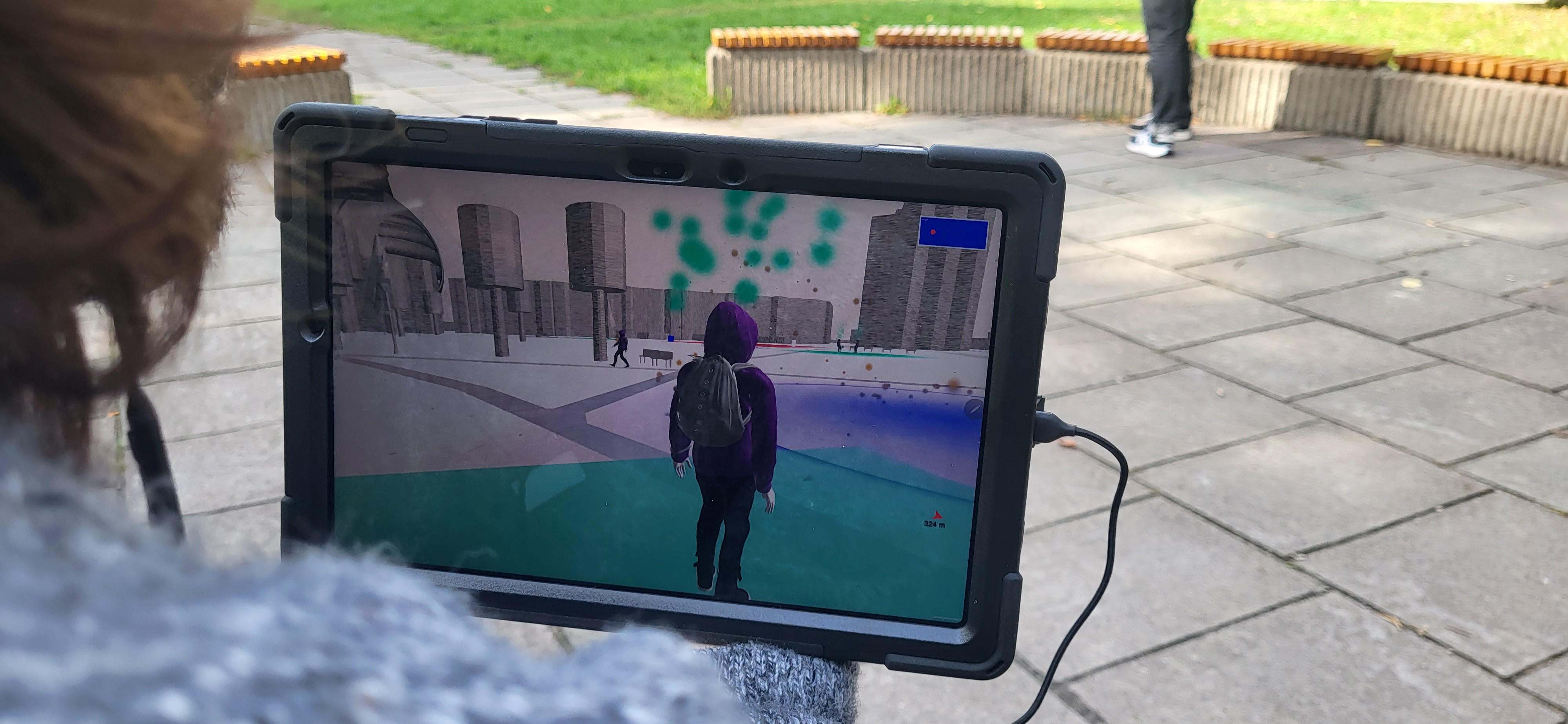 A person in the real world looks at a monitor with augmented reality in which he sees himself as a figure.