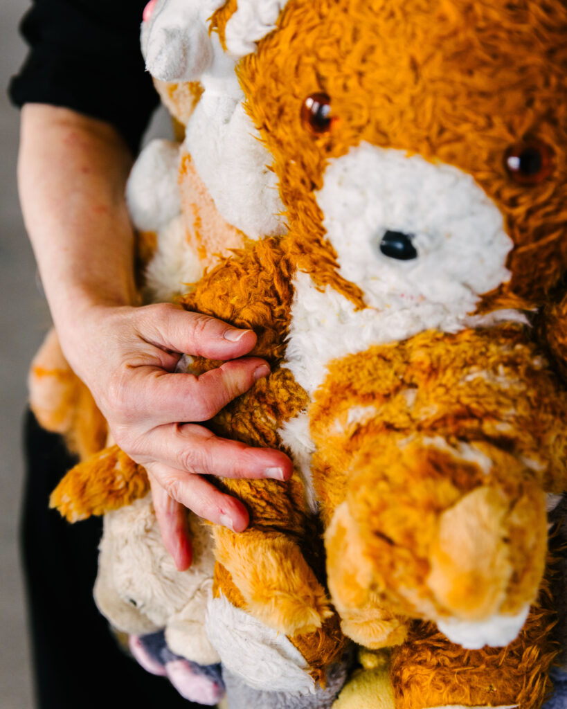 Eine Frau berührt ein Kuscheltier an ihrem Instrument