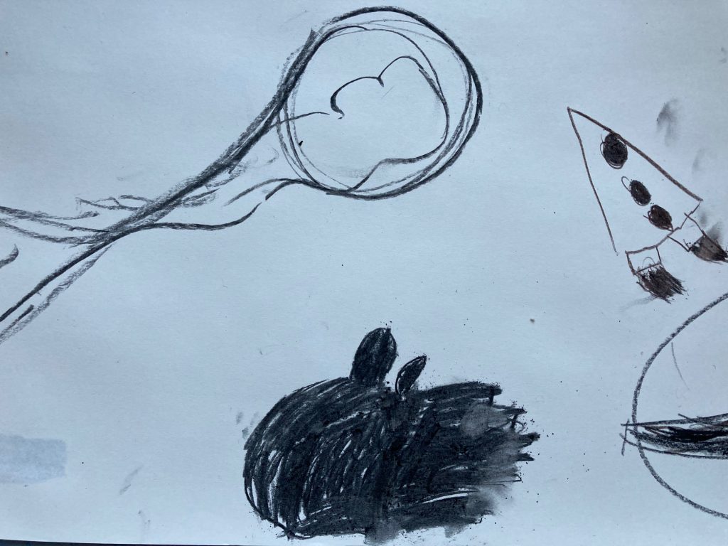 mit Zeichenkohle wure auf weißes papier ein schwarzes längliches dichtes Knäuel schraffiert, daneben eine Ballon ähnliche Zeichnung mit Kopf und Schwanz und eine kleine spitze Rakete
