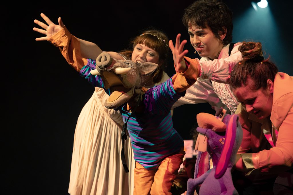 Ein Klappmaulschwein wird von zwei Studierenden geführt.